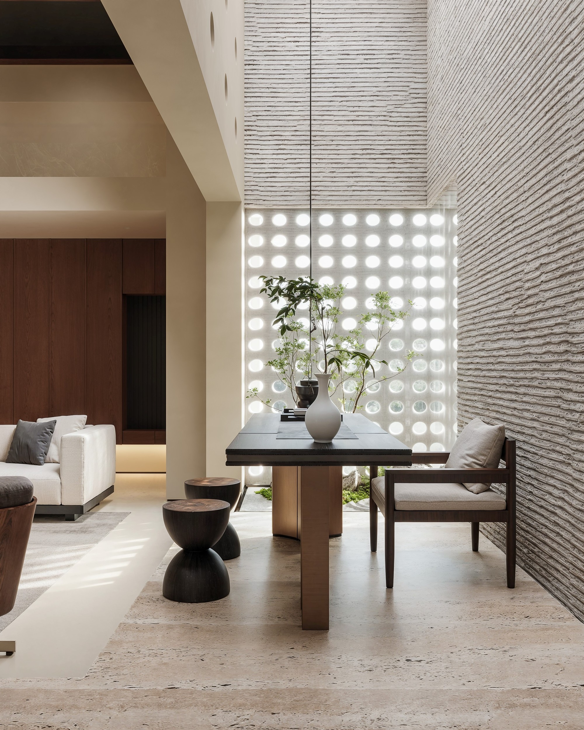 Lower-level lounge framed by a perforated daylight wall